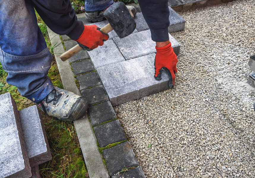 paving blocks. hand with rubber hammer install paving block